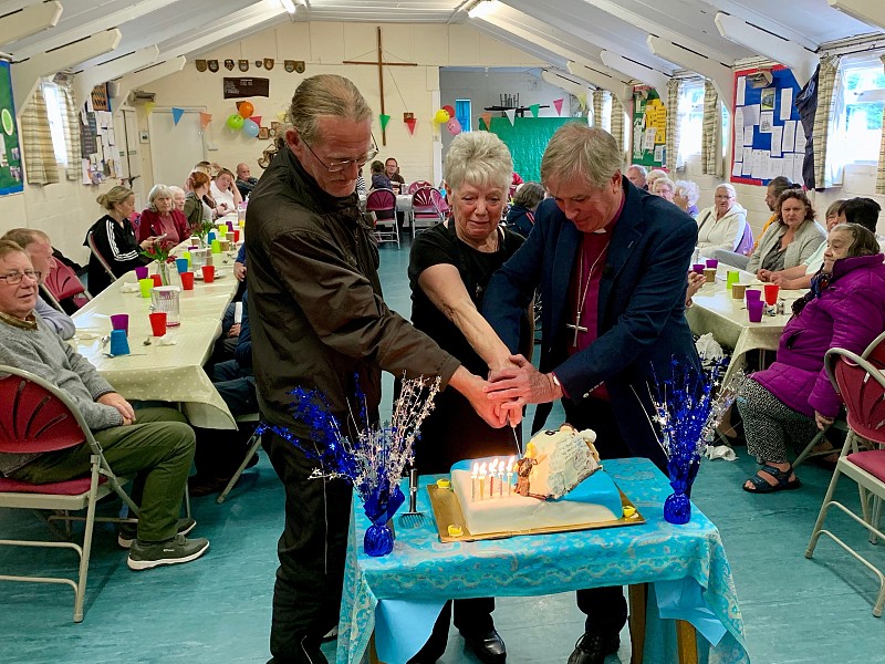Bishop Jonathan, Paul and Maggie cutting the celebration cake