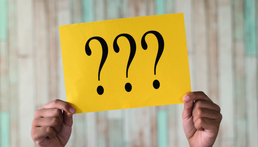 hand holding a paper note with question mark.question mark writt