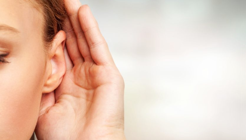 Girl listening with her hand on an