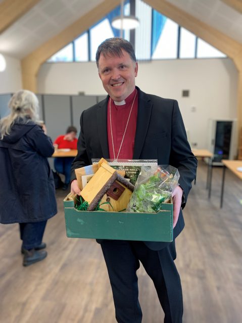 Bishop Graham receives a box of gifts, all grown or made on site at Thornage Hall.