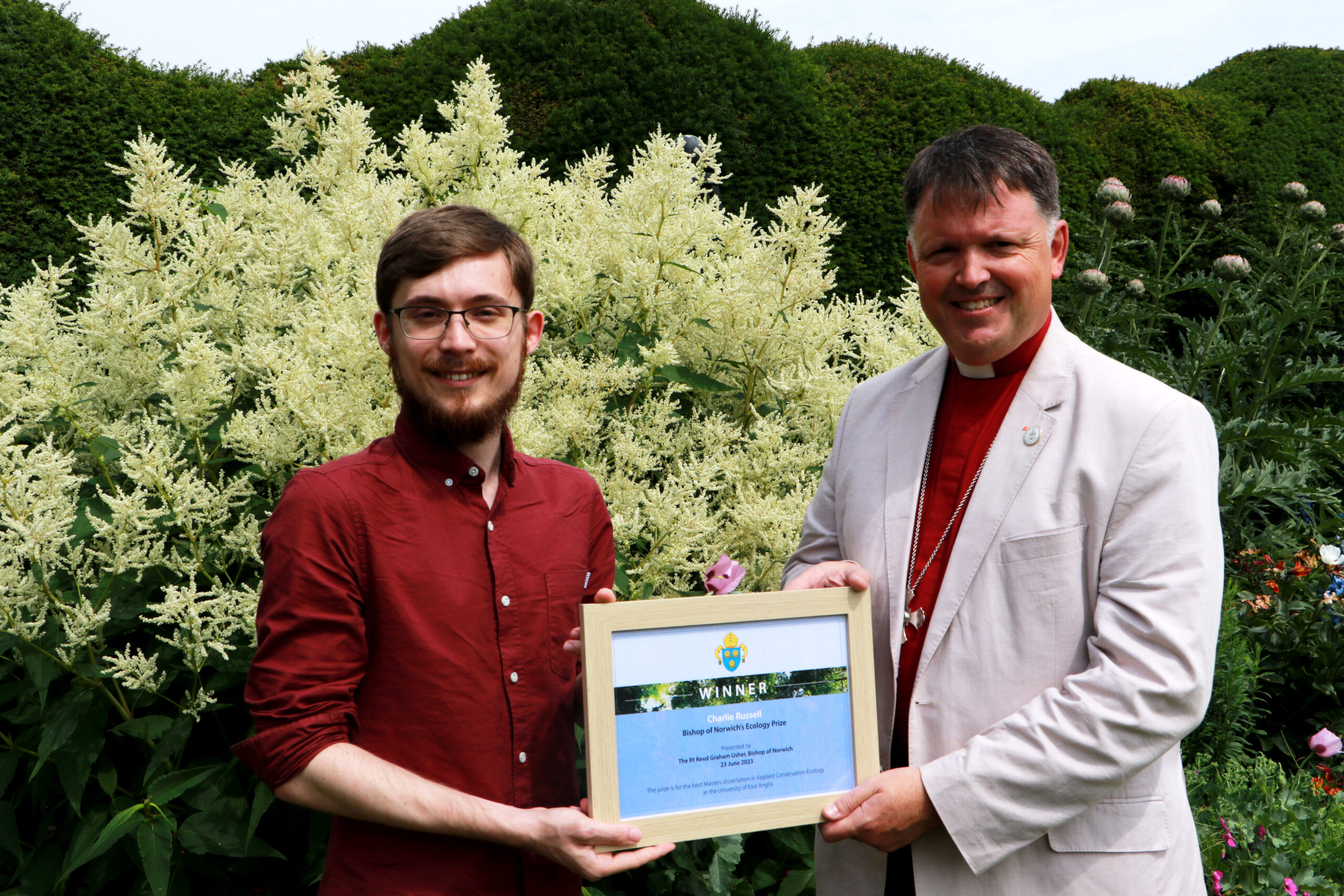 Charlie Russell being presented with his award by Bishop Graham