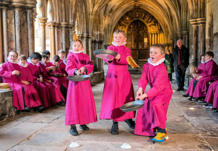 Choristers racing around the cloisters of Norwich Cathedral with frying pans.