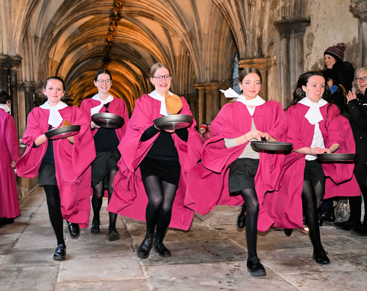 Choristers racing around the cloisters of Norwich Cathedral with frying pans.