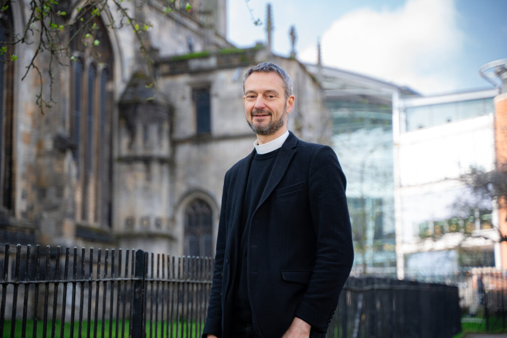 Revd Canon Edward Carter standing outside St Peter Mancroft Church in Norwich. 