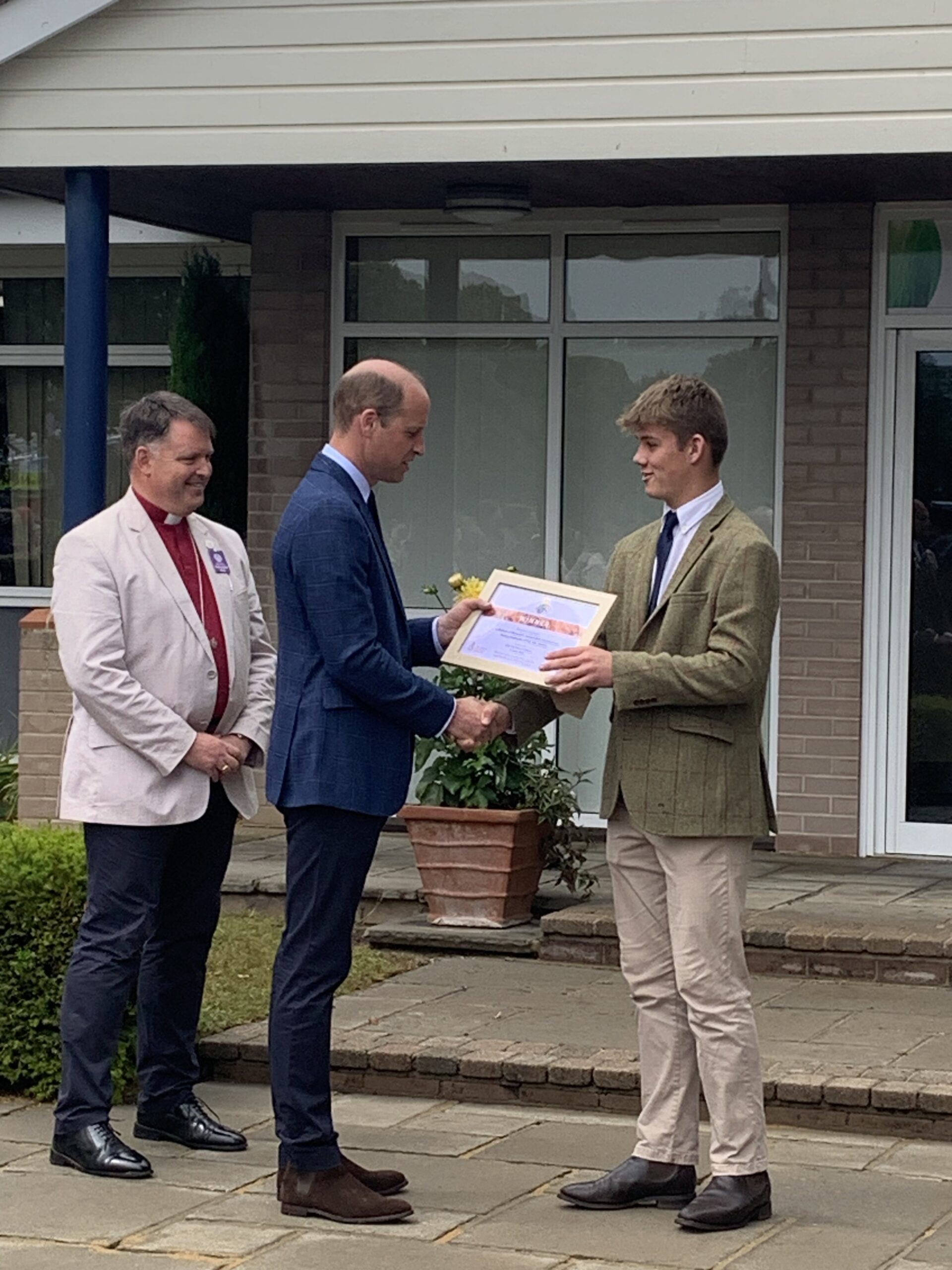 Prince William presents the Sustainable Environment Young Employee of the year award to Robert Jacket with the Bishop of Norwich looking on.