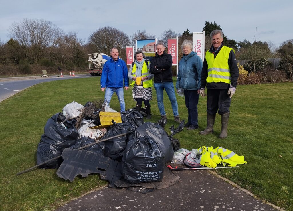 A group of people from St Andrews Holt Eco Church group on their third annual Litter Pick. The group are wearing high vis vests and standing next to some rubbish bags,